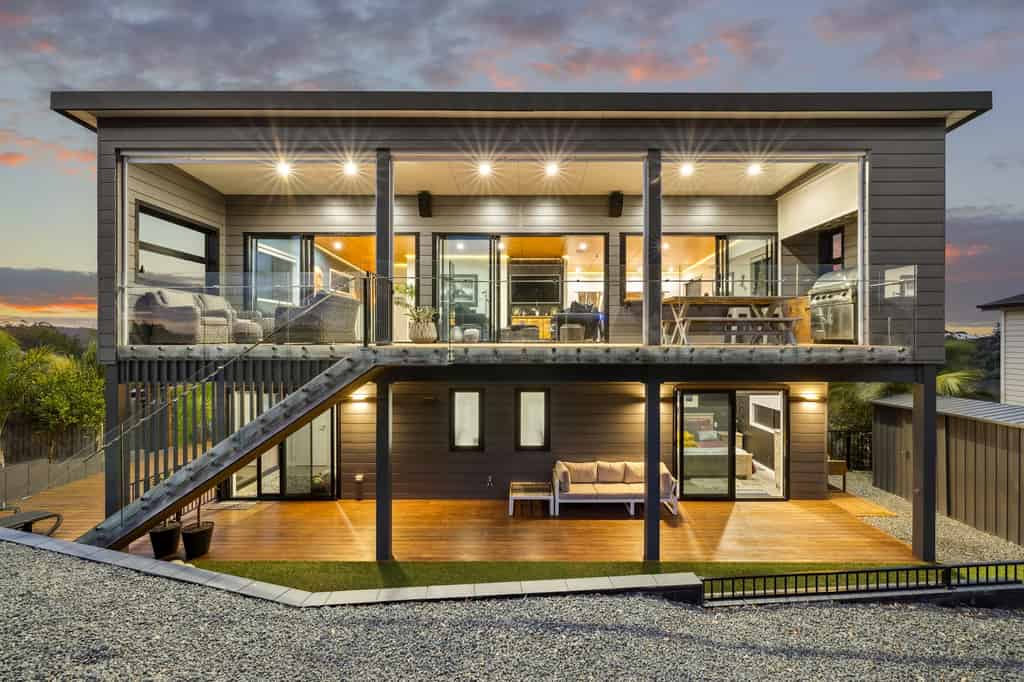 Rear elevation and two levels of decks at dusk